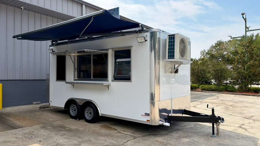 White concession trailer with extended awning, service window and rooftop air conditioning